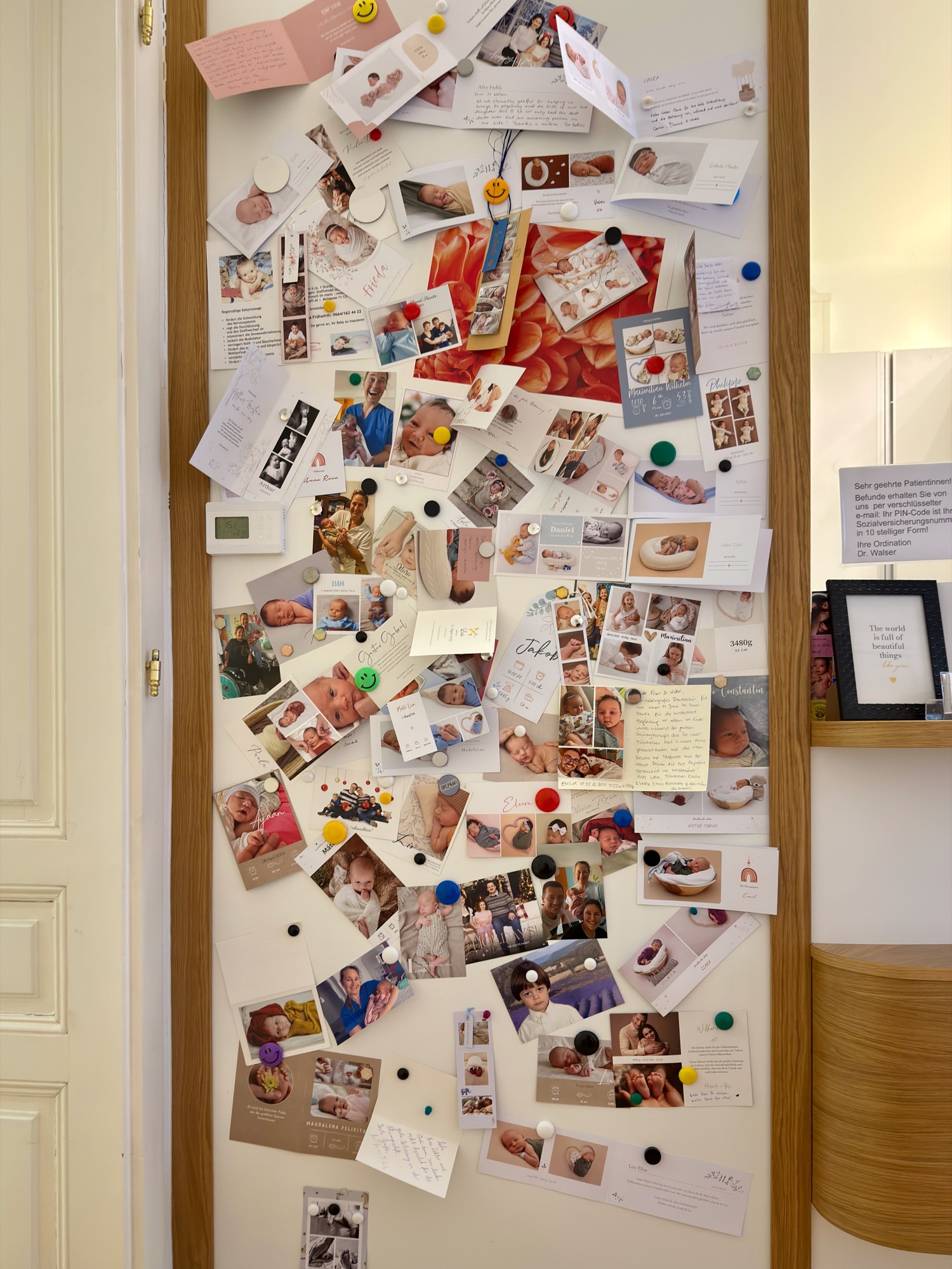 Babywand mit Dankeskarten, Geburtsanzeigen und Fotos vieler Familien